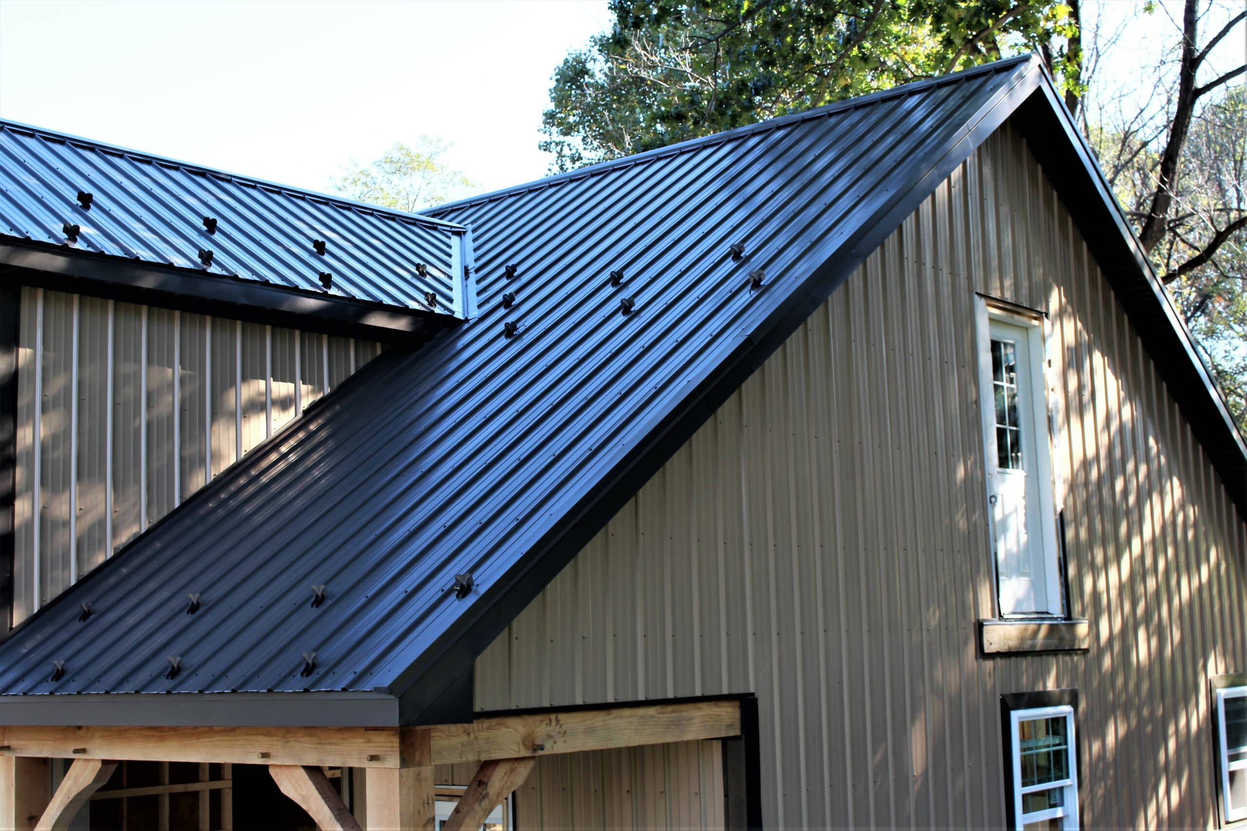 Building with gray Wagler Panel siding and black metal roof