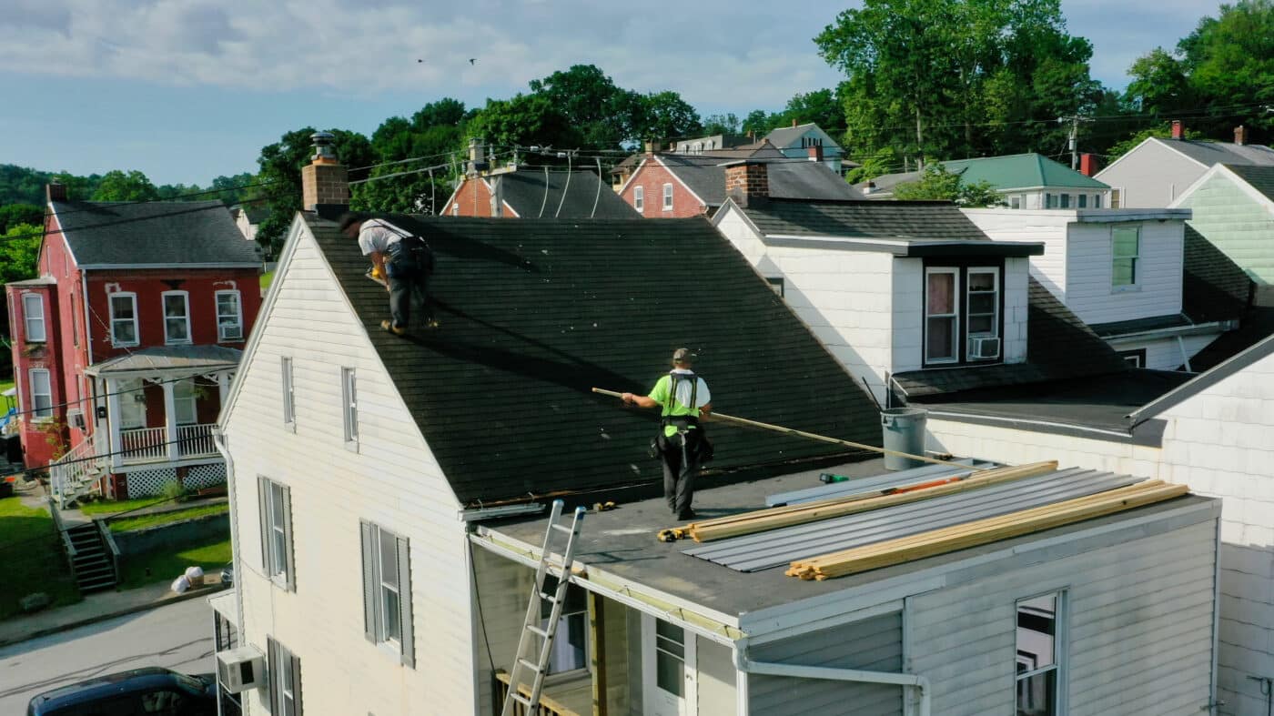 Crew preparing the surface of a roof before metal roofing installation