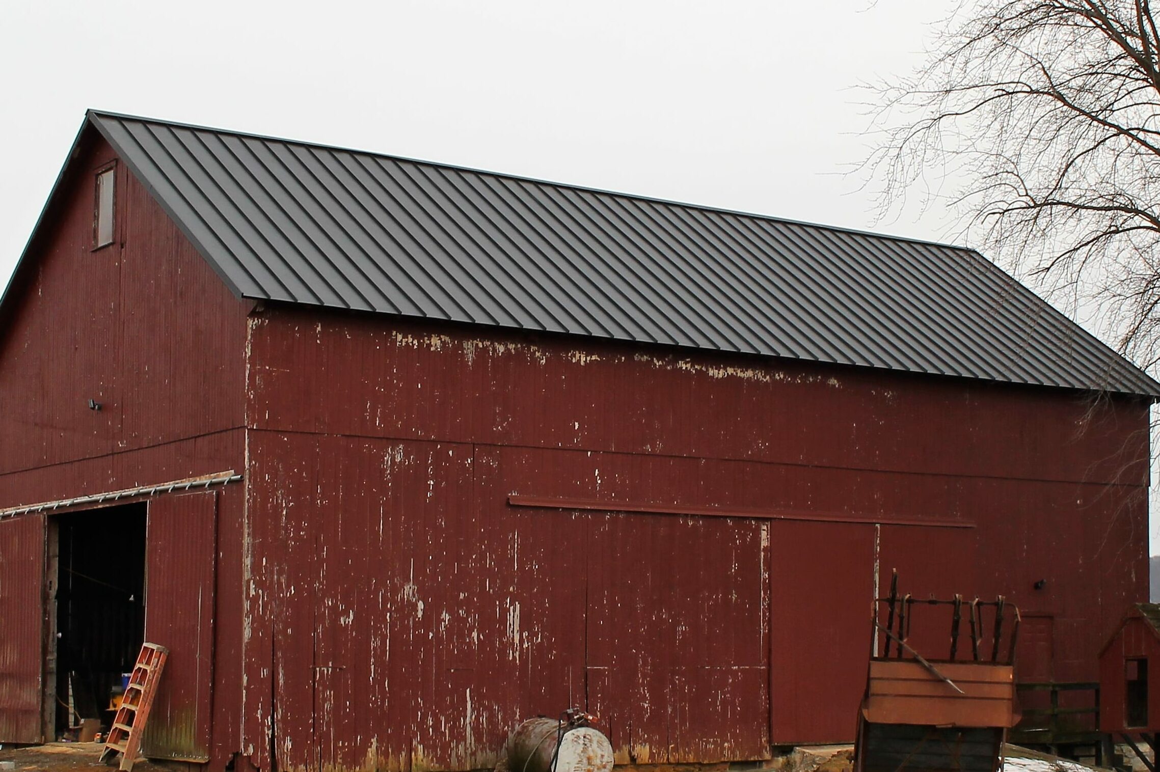 Dark Standing Seam metal roof on an old red barn
