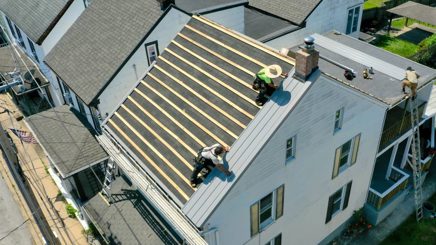 First metal panel being placed on a roof
