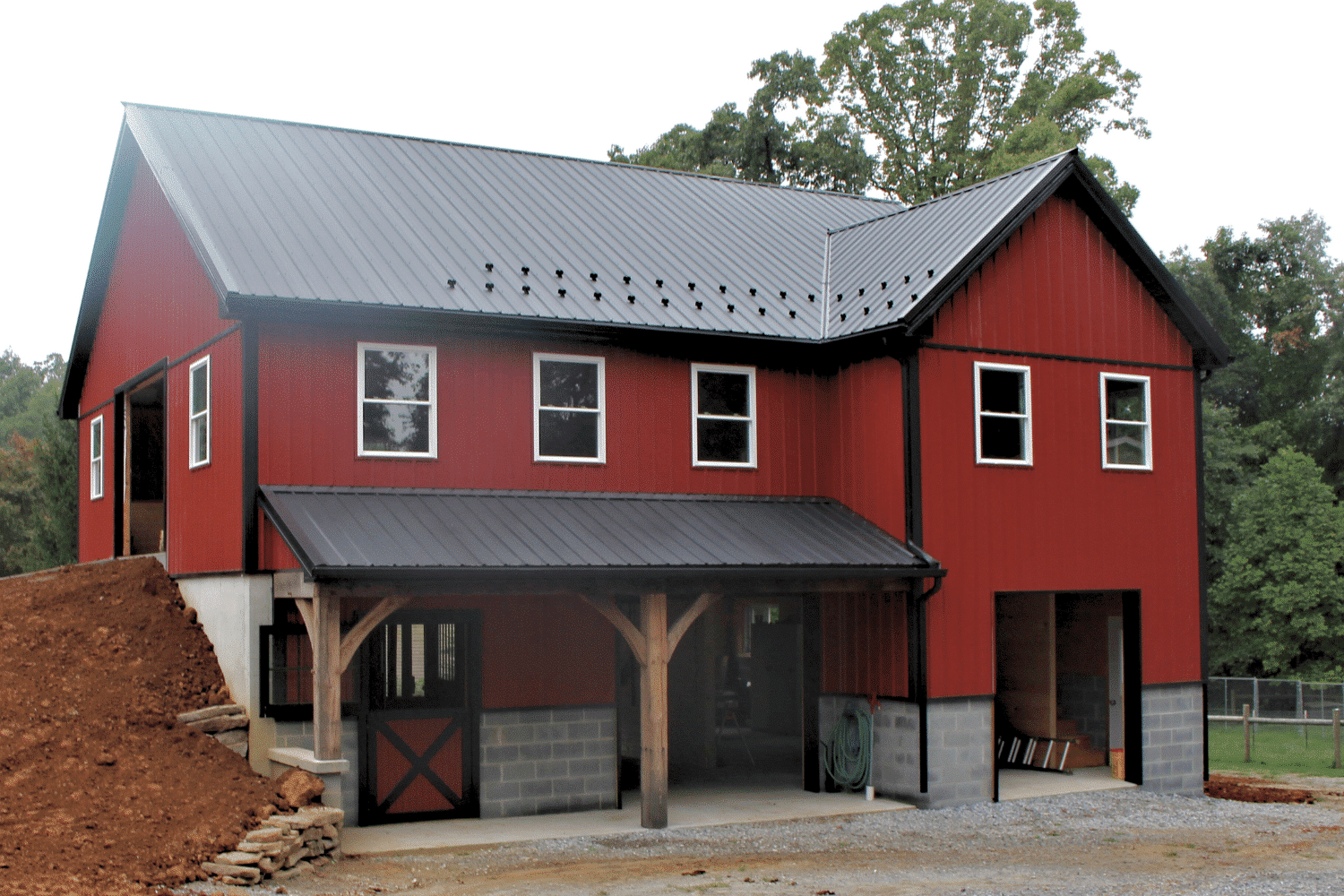 New barn with red metal siding and black metal roof