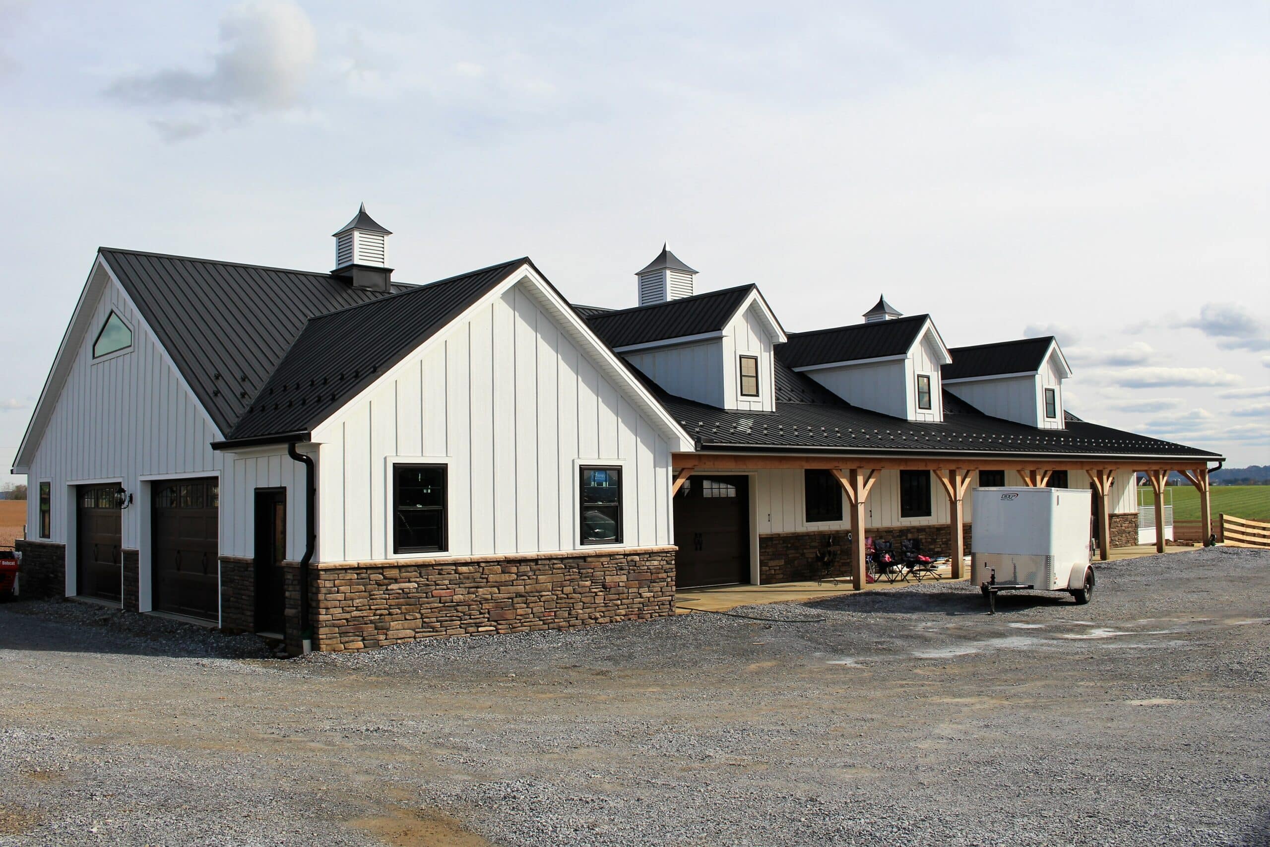 Structure with black metal roof and white metal siding