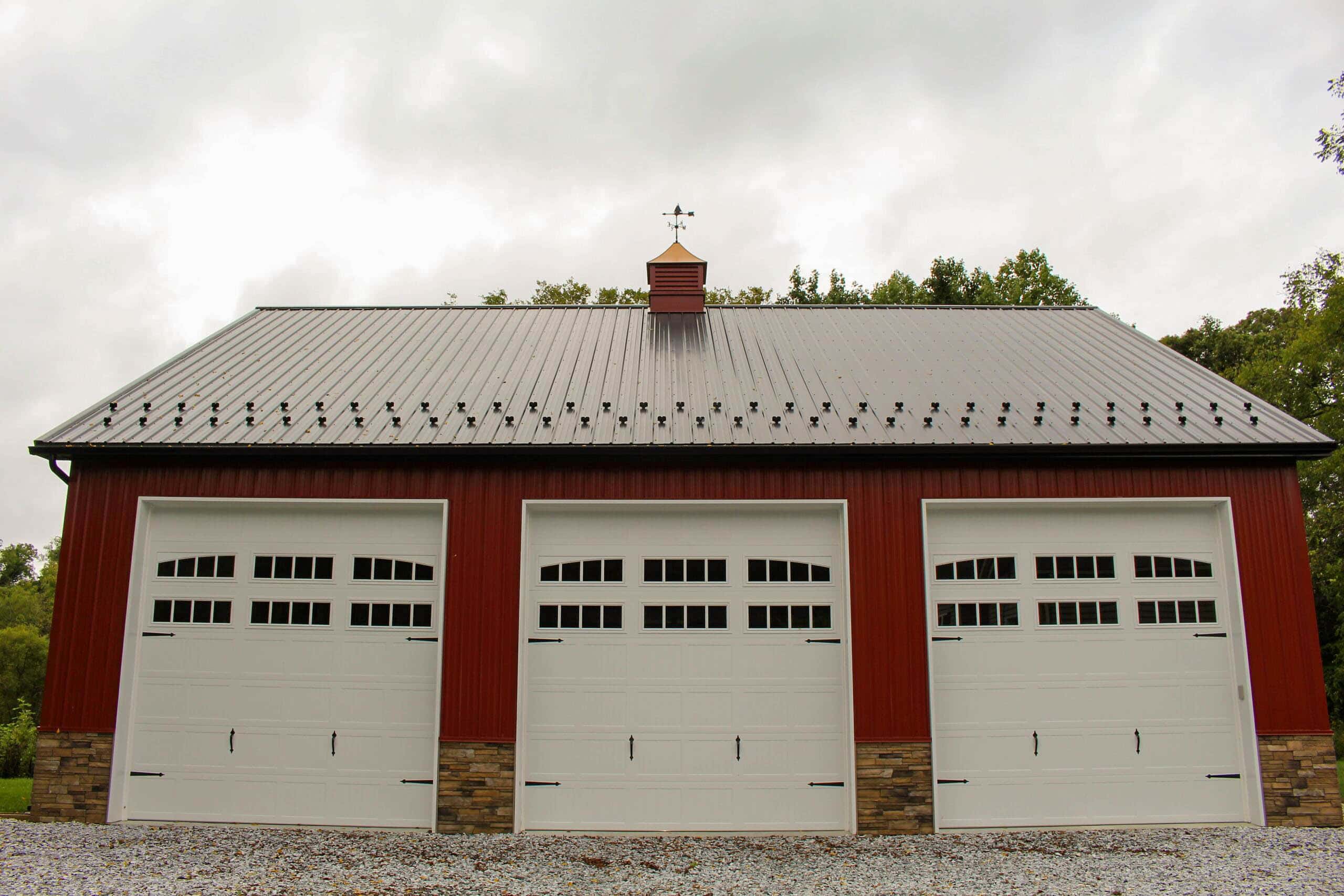 A red three-car garage with a black metal roof in mt holly nj